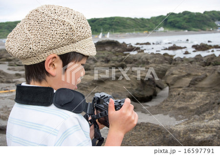 海岸で撮影する子供。小さなカメラマン（三浦半島、長浜海岸） 16597791