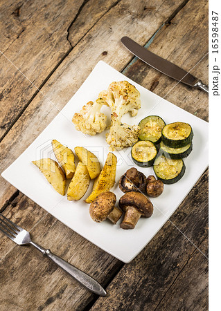 Roasted vegetables with sauce served on wood table 16598487