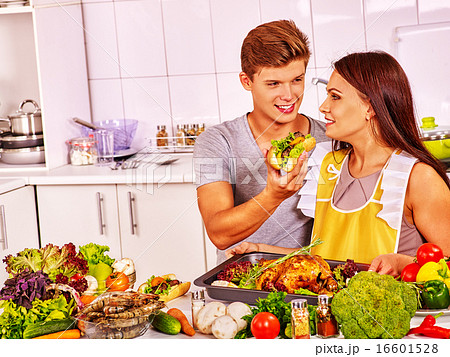 Couple cooking chicken at kitchen. 16601528