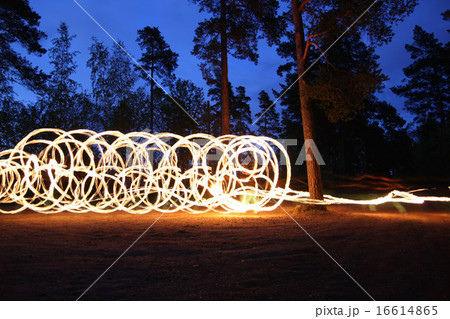 Fire spinning at night in forest 16614865