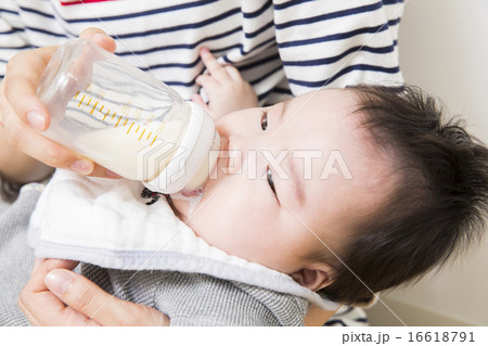 赤ちゃんにミルクをあげるお父さんとお母さん 赤ちゃんにミルクをあげるお父さんとお母さん 16618791