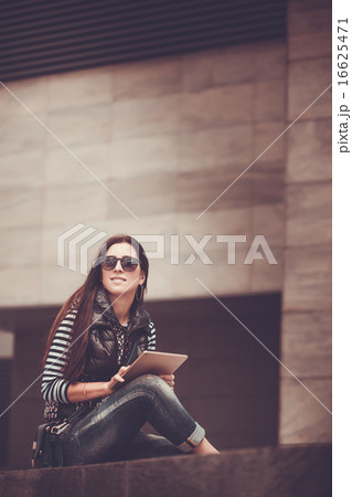 girl with tablet is walking in the downtown girl with tablet is walking in the downtown 16625471