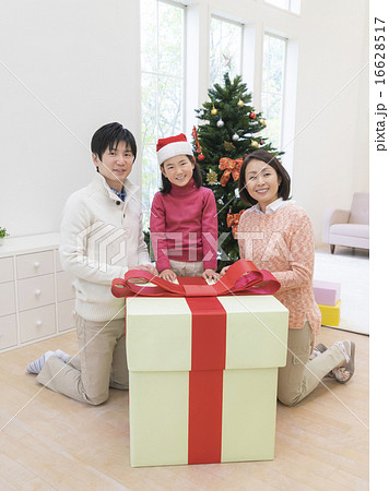 大きなプレゼントボックスを前に微笑む家族 大きなプレゼントボックスを前に微笑む家族 16628517