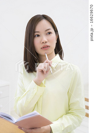 ペンをあごにあてる女性 16629670
