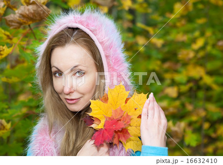 woman in autumn park with maple leaves 16632410