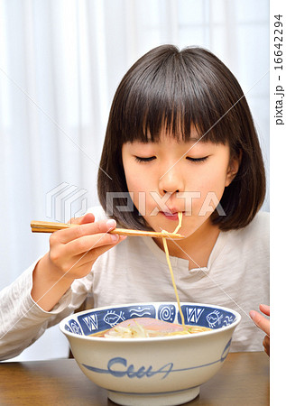 ラーメンを美味しそうに食べる女の子の写真素材