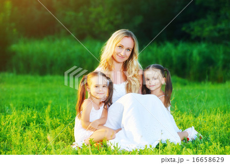 happy family mother and children twin sisters on meadow in summe 16658629