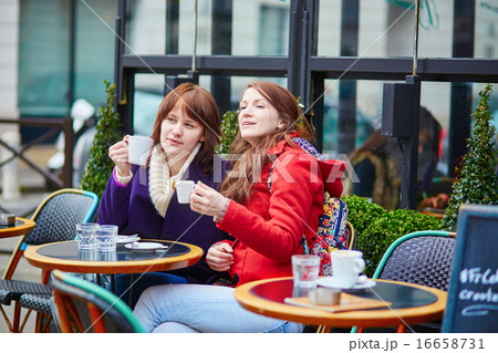 Two beautiful young girls drinking coffee 16658731