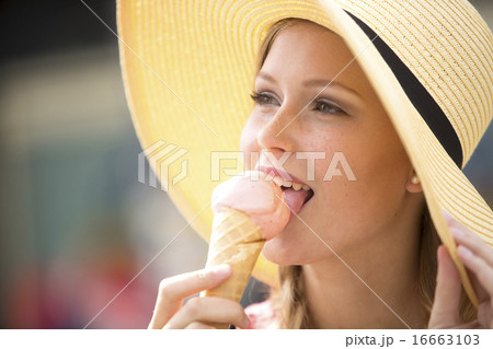 Pretty young girl eating ice cream wearing a hat 16663103