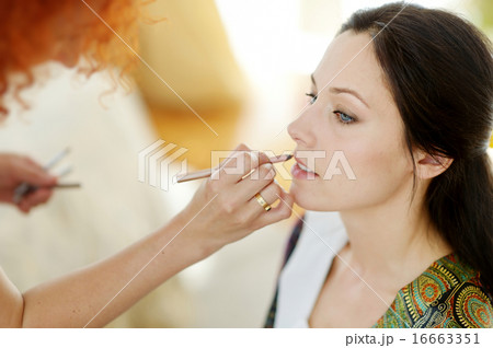 Young beautiful bride applying wedding make-up 16663351
