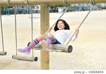 公園のブランコで遊ぶ女の子 16668808