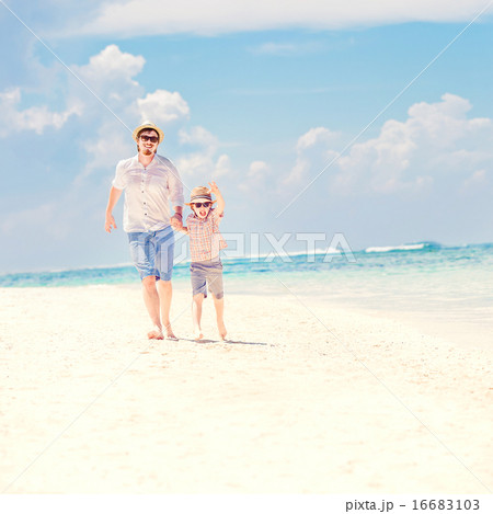 Father with son running barefoot on the sea surf line having great holidays time Father with son running barefoot on the sea surf line having great holidays time 16683103