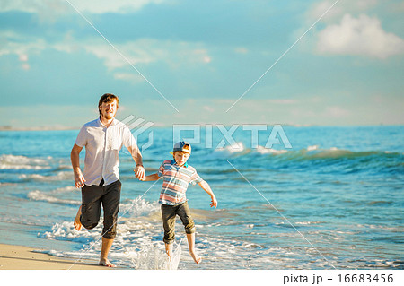 Father and son having great family time at ocean shore on summer holidays Father and son having great family time at ocean shore on summer holidays 16683456