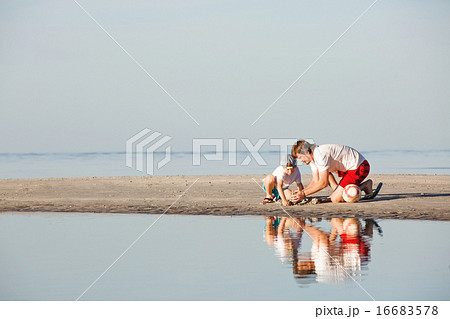 Happy father and son having great time on the beach in sunset light 16683578