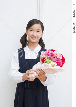 花束を持つ中学生の女の子の写真素材