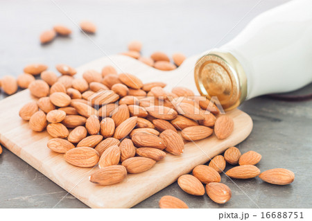 Almond nuts on wooden plate with milk Almond nuts on wooden plate with milk 16688751
