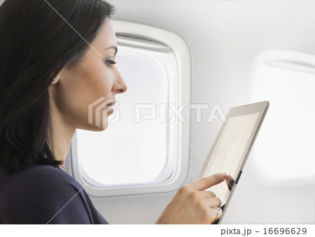 Young woman using tablet on plane 16696629