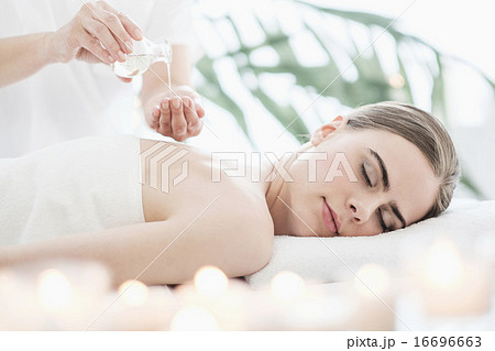 Therapist putting massaging oil on young woman in spa Therapist putting massaging oil on young woman in spa 16696663