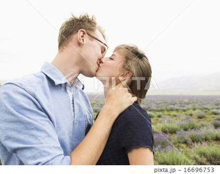 Young couple kissing with field on background 16696753
