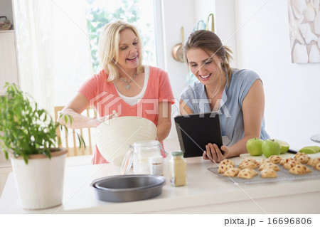 Mother with adult daughter baking in kitchen 16696806