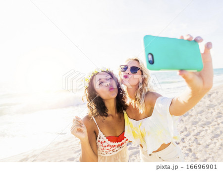 Female friends taking selfie on beach Female friends taking selfie on beach 16696901