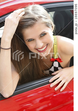 Portrait of smiling woman in red car 16697096