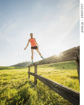 Woman balancing on wooden fence Woman balancing on wooden fence 16697207