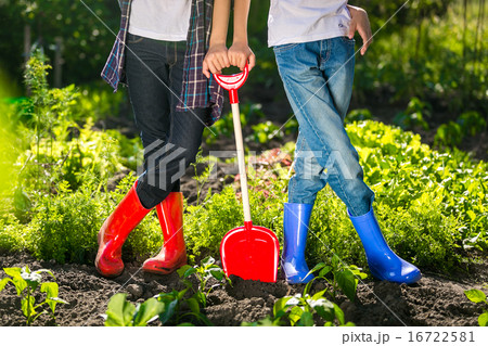 two girls in gumboots standing at garden two girls in gumboots standing at garden 16722581