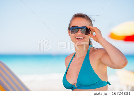 Portrait of smiling woman in sunglasses on beach 16724881