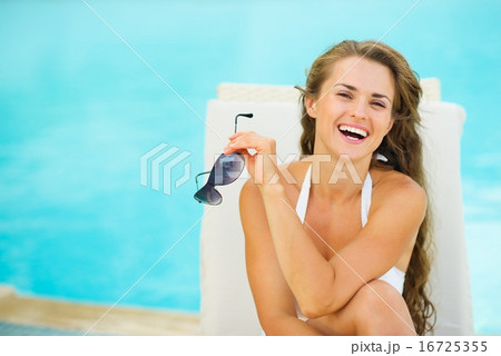 Portrait of happy young woman in swimsuit relaxing poolside Portrait of happy young woman in swimsuit relaxing poolside 16725355