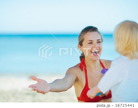 Happy mother playing with baby girl on beach Happy mother playing with baby girl on beach 16725441