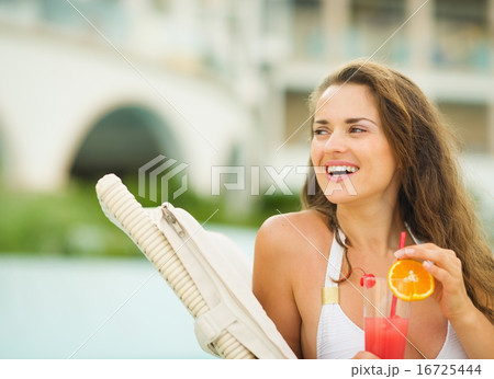 Happy young woman with cocktail looking on copy space 16725444