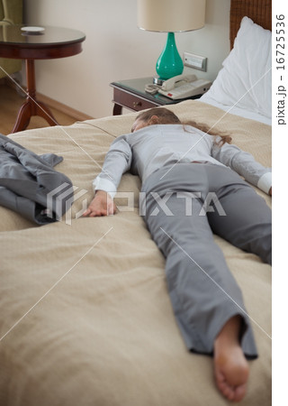Tired business woman fall down from exhaustion in hotel room 16725536