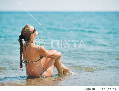 Young woman sitting at seaside . rear view Young woman sitting at seaside . rear view 16725593