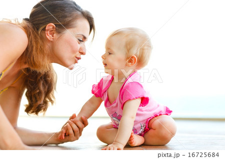 Young mother playing with baby on floor Young mother playing with baby on floor 16725684