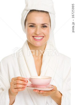 Happy young woman in bathrobe holding cup of tea 16725995