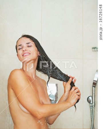 Happy young woman washing hair in shower 16726148