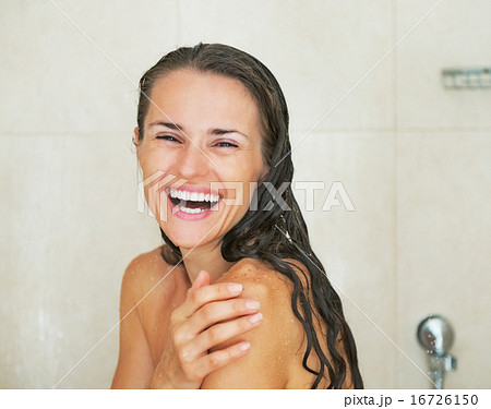 Portrait of smiling young woman in shower 16726150