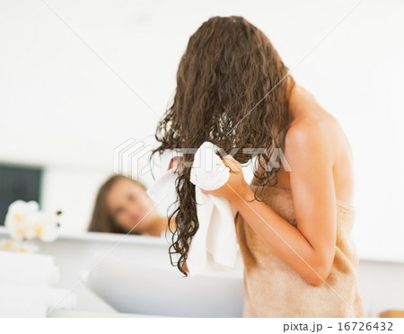 Young woman wiping hair with towel. rear view 16726432