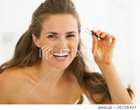 Happy young woman with tweezers 16726437