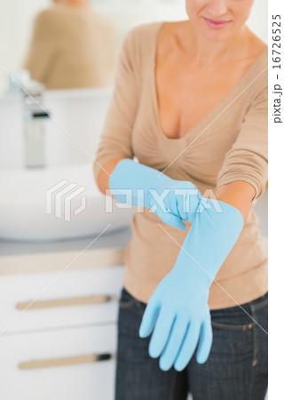 Closeup on young housewife wearing gloves Closeup on young housewife wearing gloves 16726525