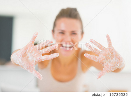 Closeup on smiling young woman showing hands with soap foam 16726526