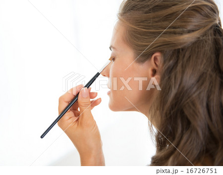Young woman applying makeup 16726751