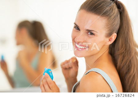 Portrait of happy young woman with dental floss Portrait of happy young woman with dental floss 16726824