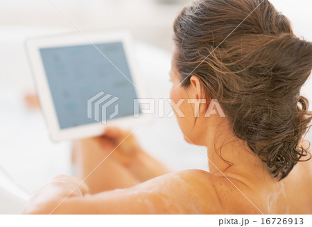 Young woman using tablet pc in bathtub. rear view 16726913