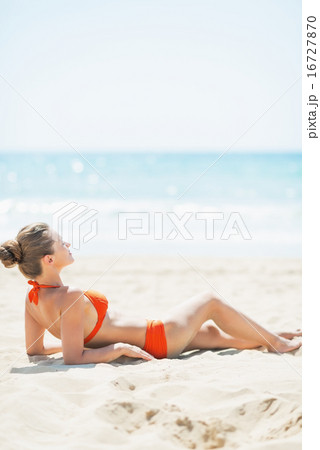 Relaxed young woman laying on beach 16727870