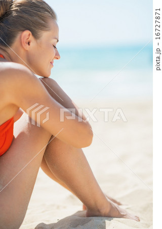 Relaxed young woman sitting on beach Relaxed young woman sitting on beach 16727871