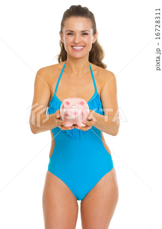 Happy young woman in swimsuit giving piggy bank Happy young woman in swimsuit giving piggy bank 16728311