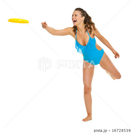 Happy young woman in swimsuit throwing flying disc Happy young woman in swimsuit throwing flying disc 16728539