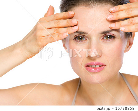 Beauty portrait of concerned young woman checking facial skin 16728858